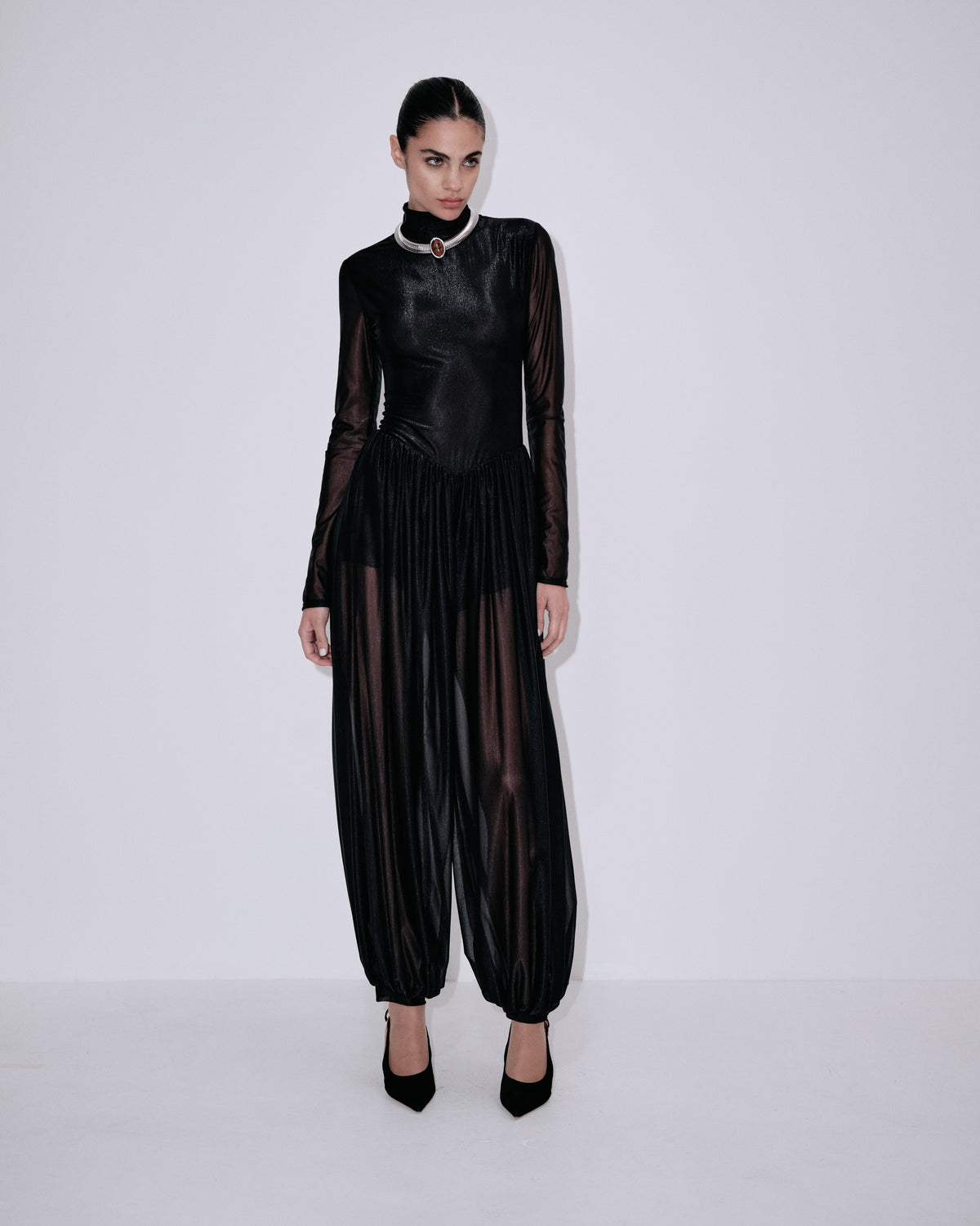 Black high-neck jumpsuit with long sheer sleeves and ruched, pleated bodice