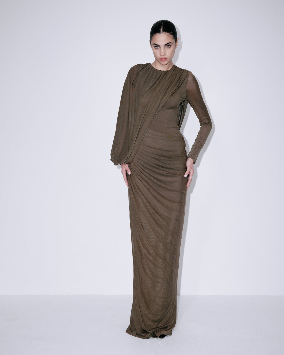 Forest green fitted maxi dress with long sleeves, ruched waist, and curved drape