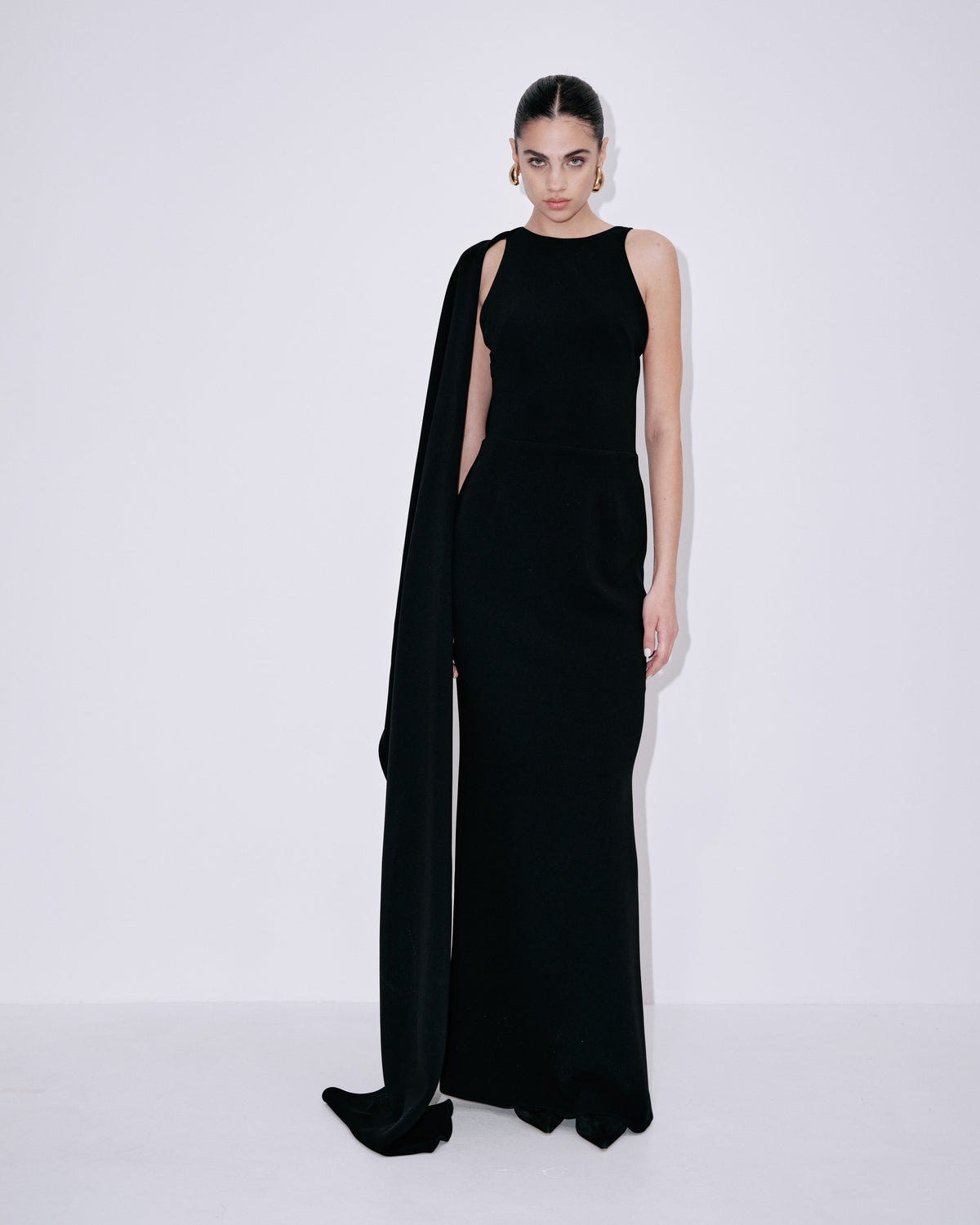 Black sleeveless maxi dress with draped shoulder overlay and fitted waist