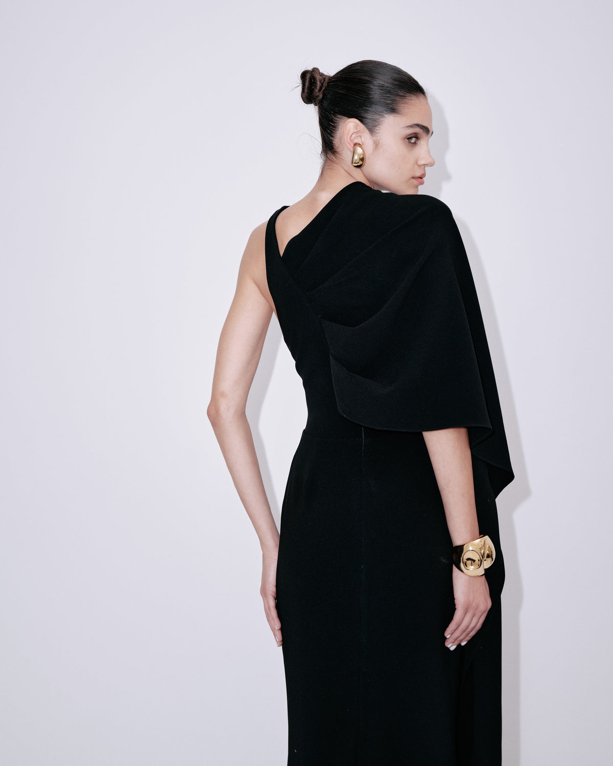 Black sleeveless maxi dress with draped back overlay and long cape-like panel
