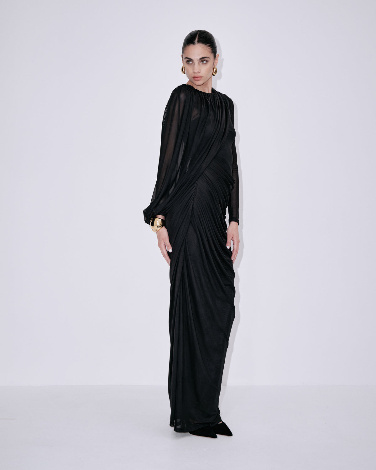 Black side-profile maxi dress with asymmetrical drape and long sleeves
