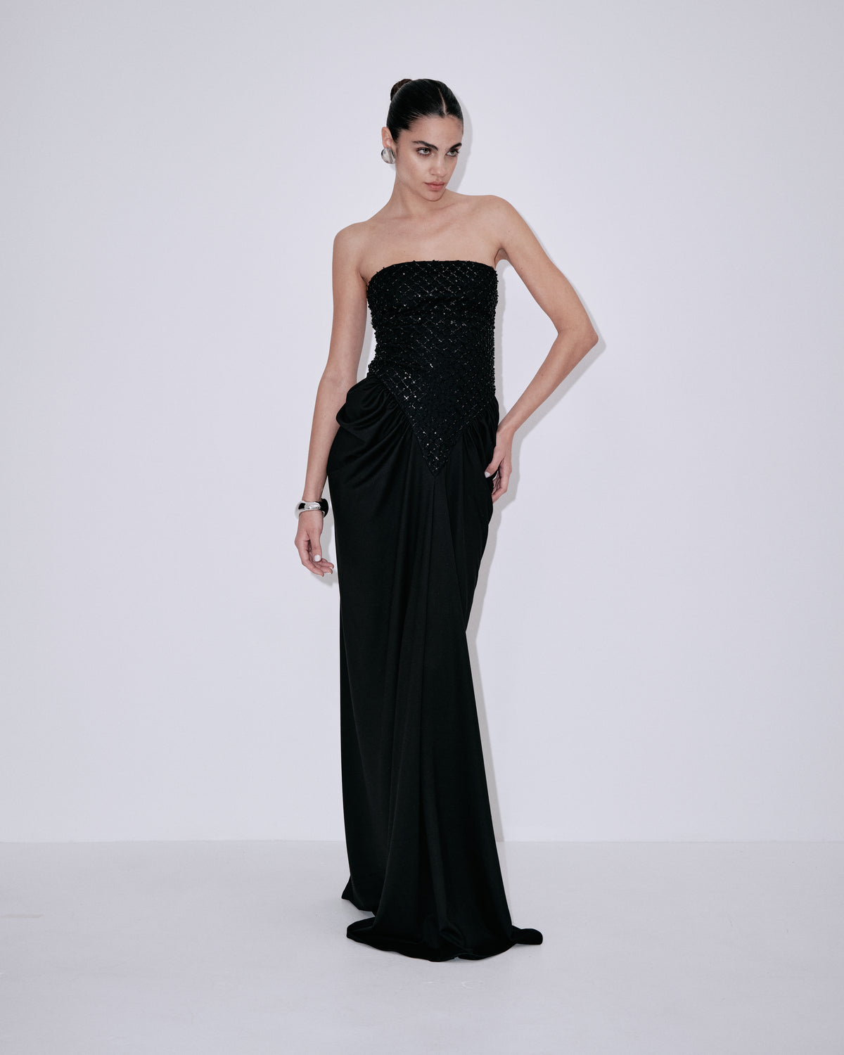 Black strapless maxi dress with sparkling corset top and flowing draped skirt, side view
