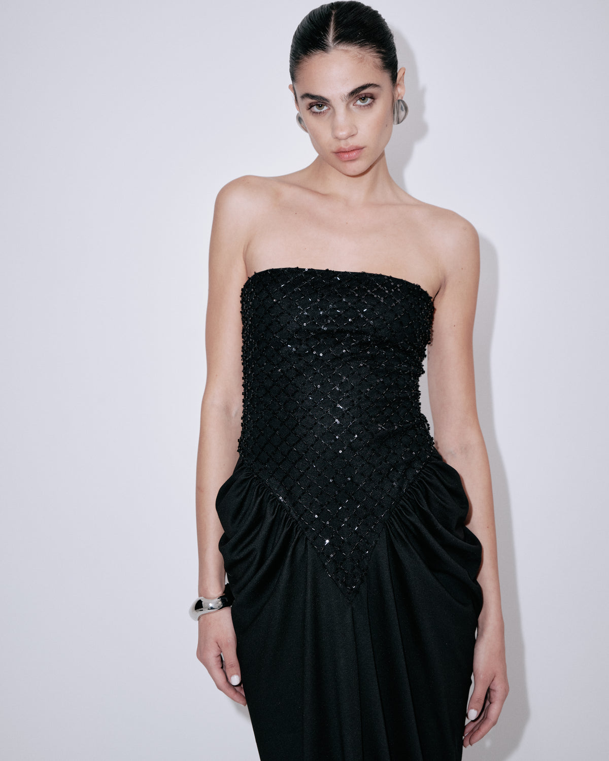 Black strapless evening dress with beaded corset bodice and draped floor-length skirt