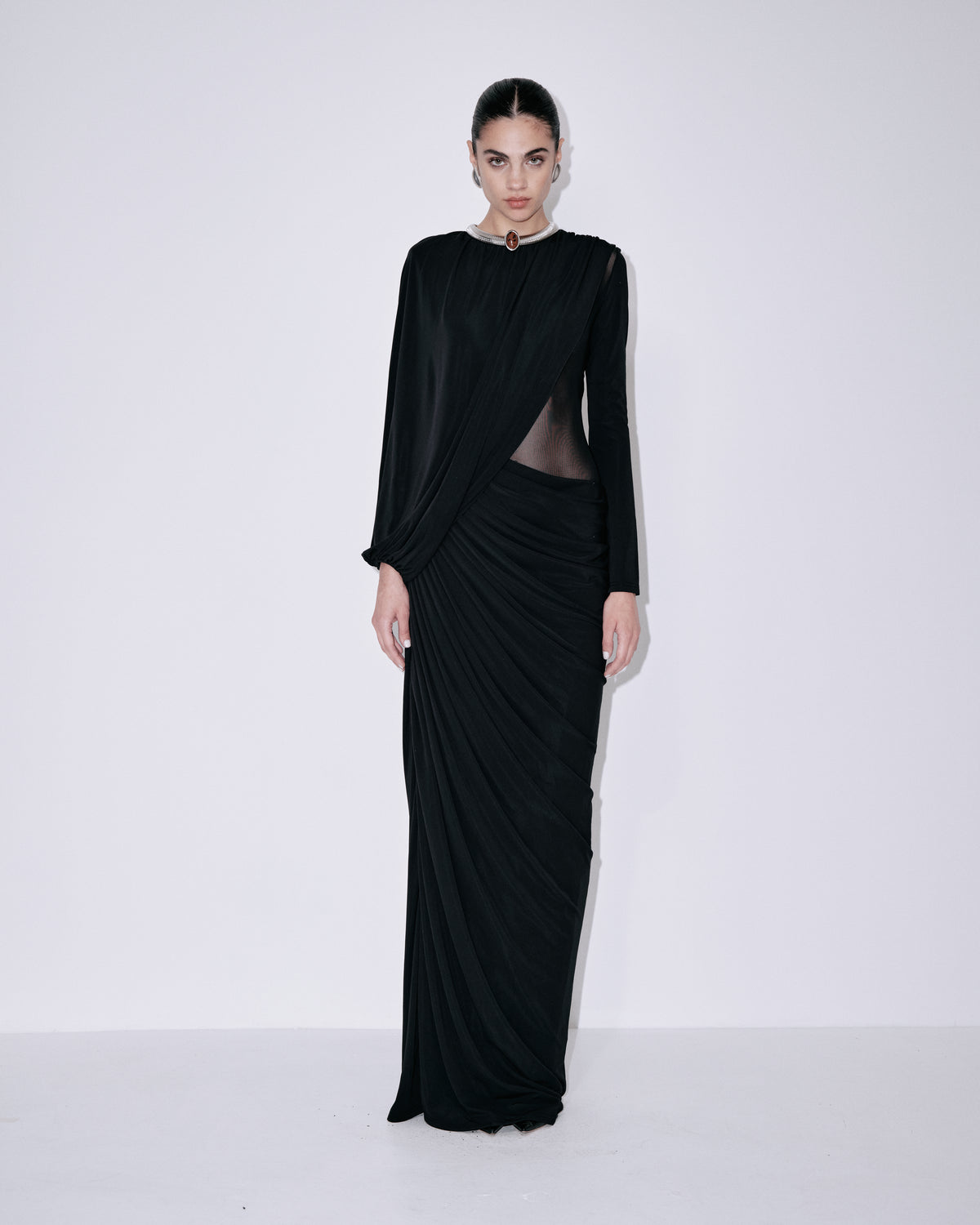 Black mesh maxi dress with long sleeves, high neck, and diagonal drape