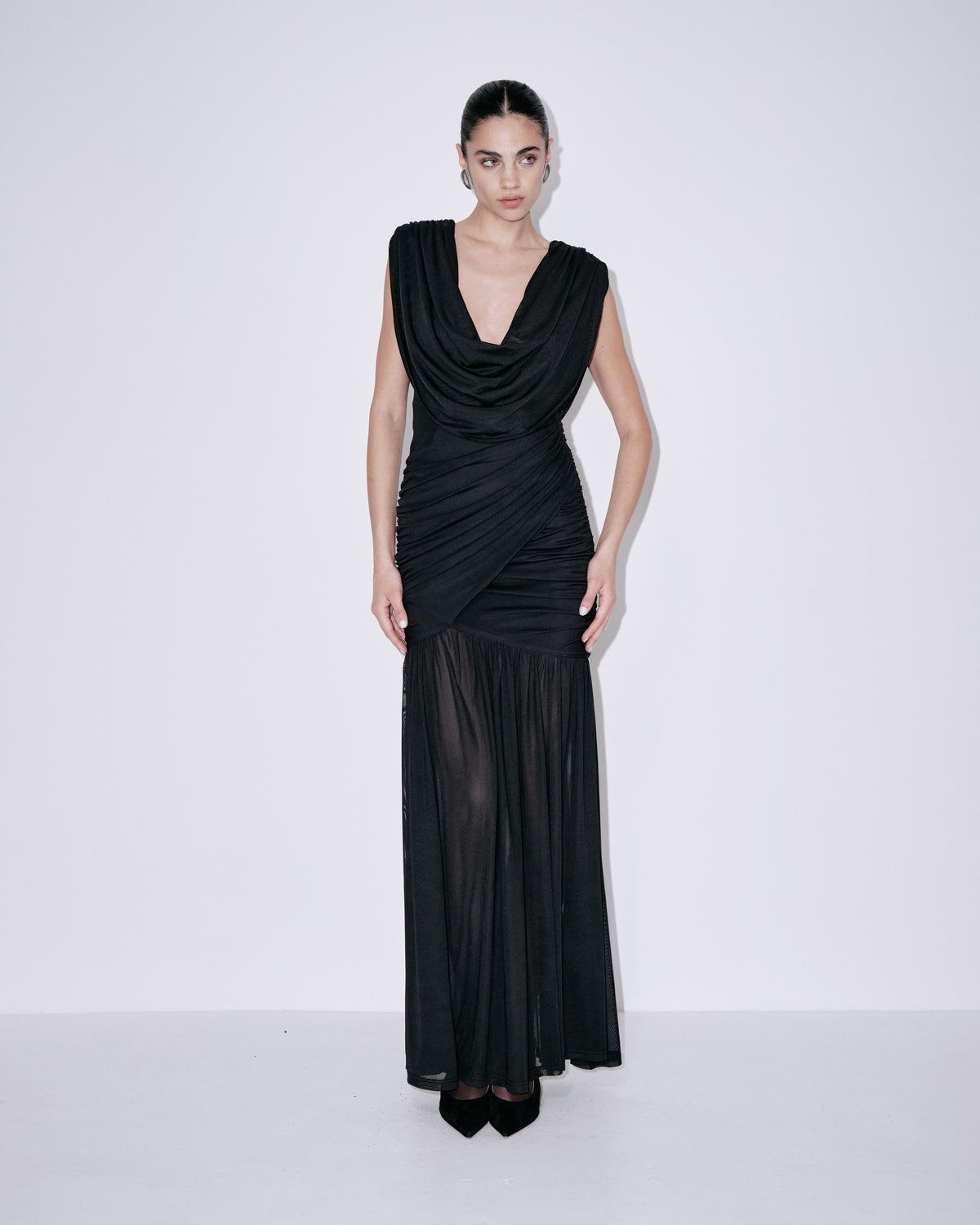 Black draped cowl-neck sleeveless dress with ruched detail and flowing pleated maxi skirt