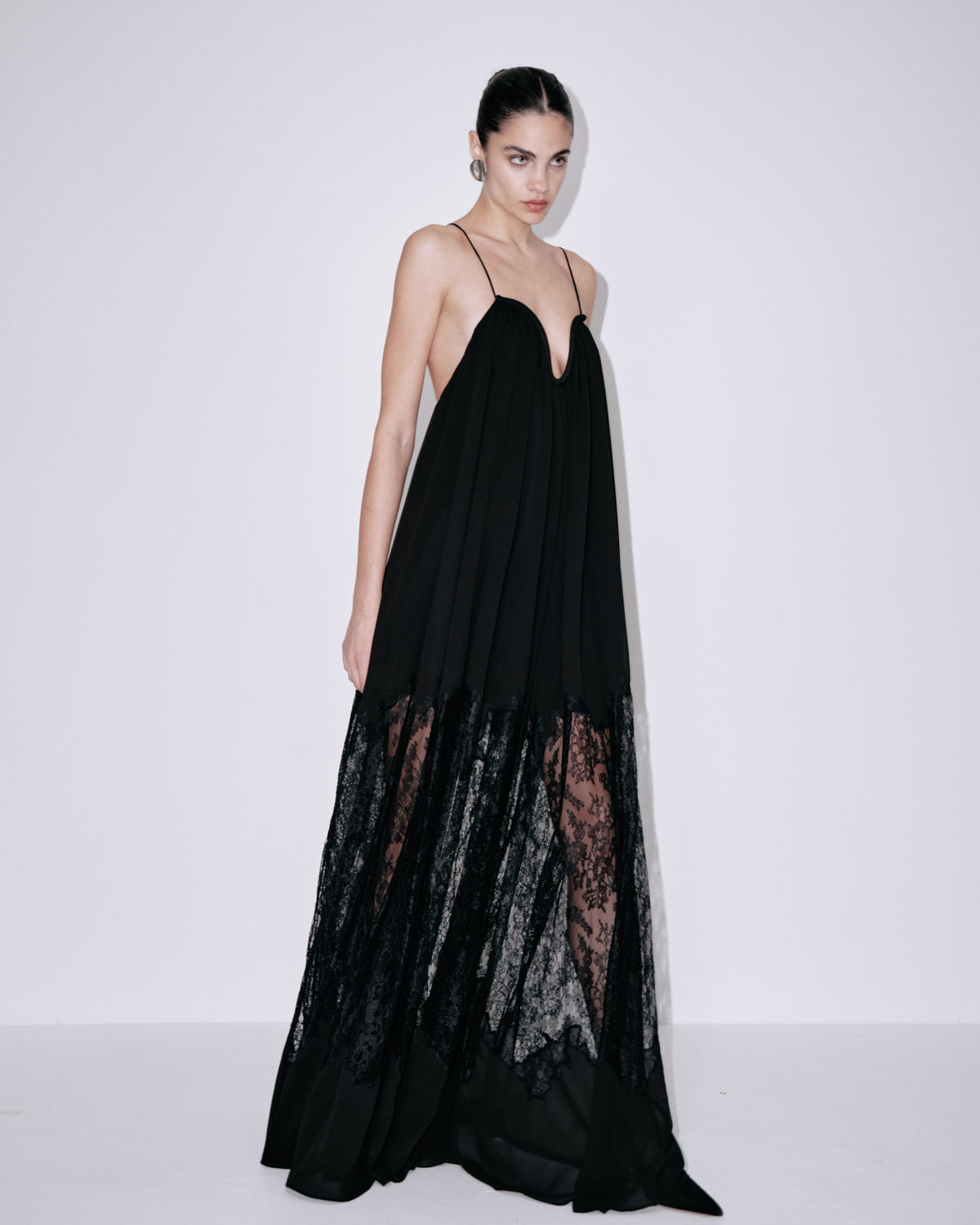 Black maxi dress with thin straps, sweetheart neckline, textured lace hem panel