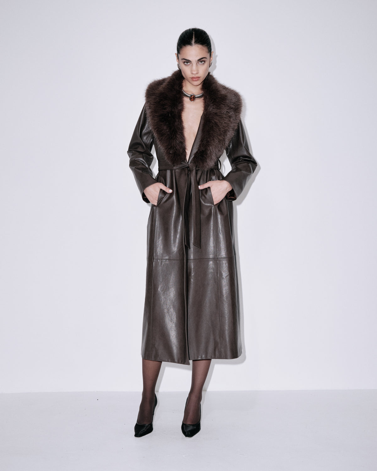 Chocolate faux-leather coat with dark fur collar, belted waist and long sleeves