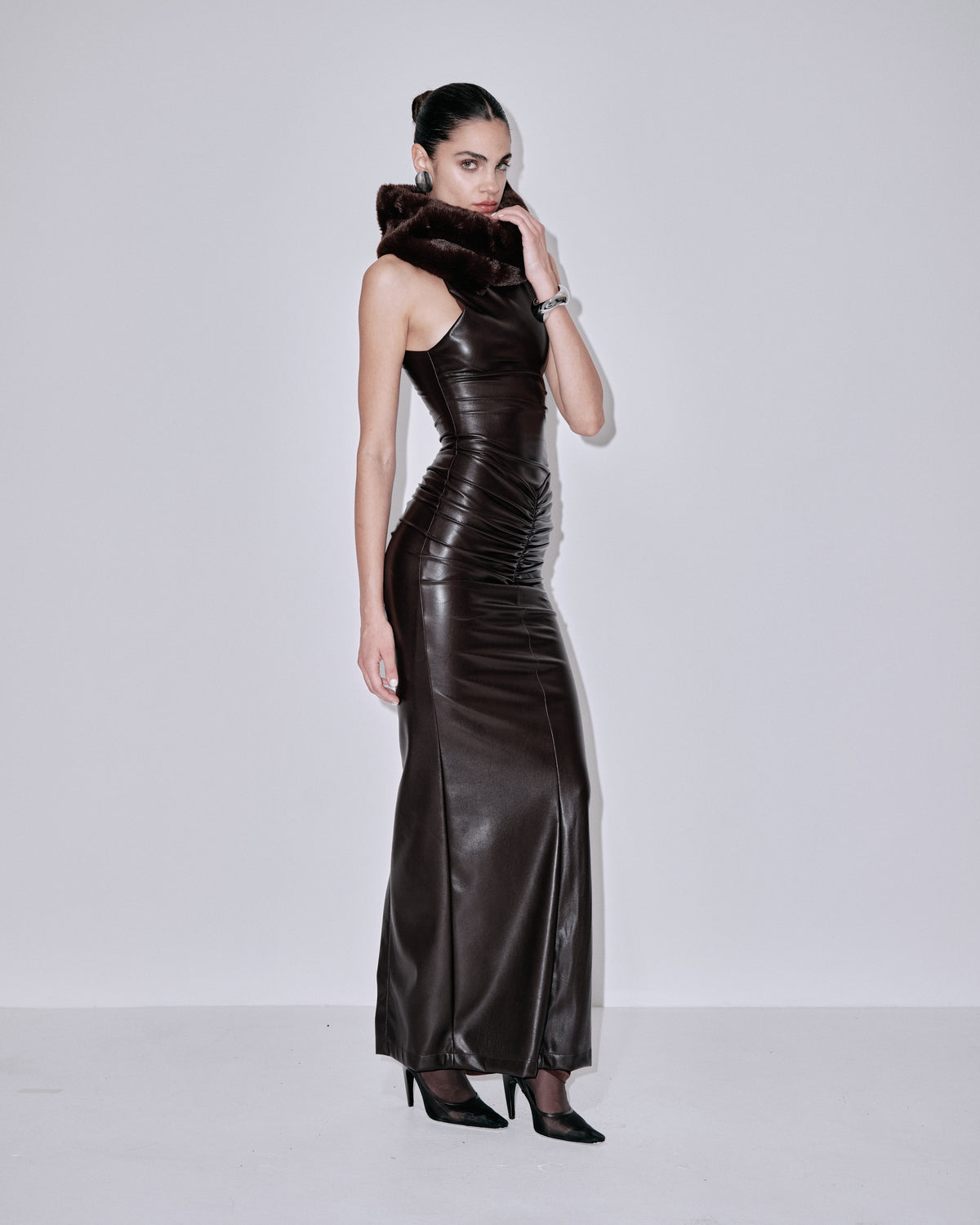 Fitted chocolate sleeveless maxi dress with high neck and fur snood, side view