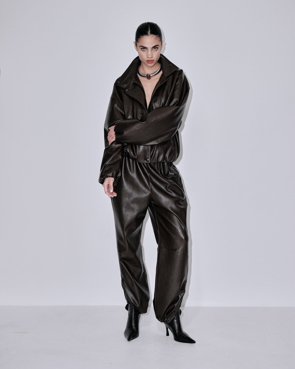 Chocolate-brown shiny jogger pants, elastic waist and relaxed taper toward ankles