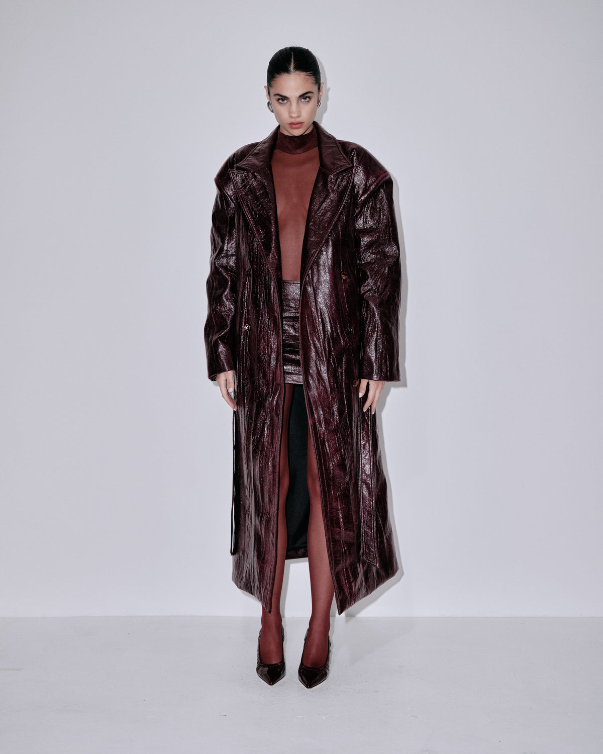 Long metallic berry coat with notched collar, side slits, and belted waist