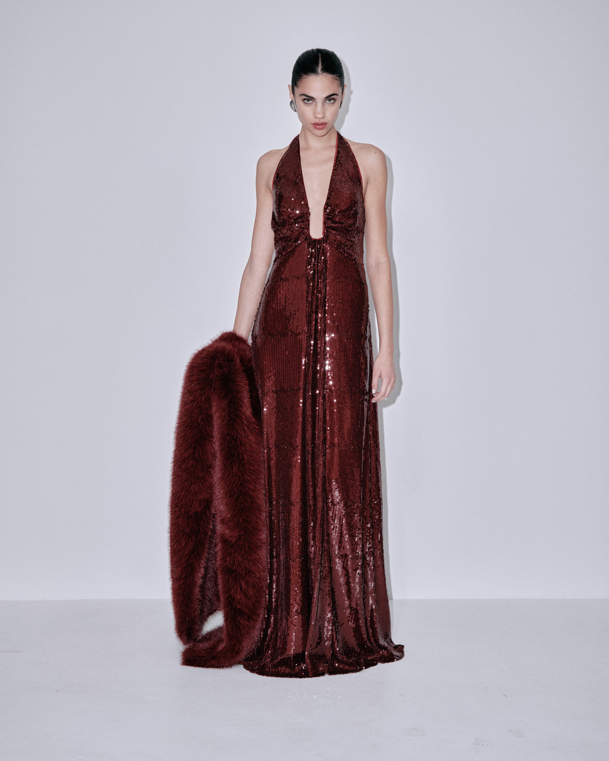 Wine sequin halter dress with faux-fur shoulder wrap, side view