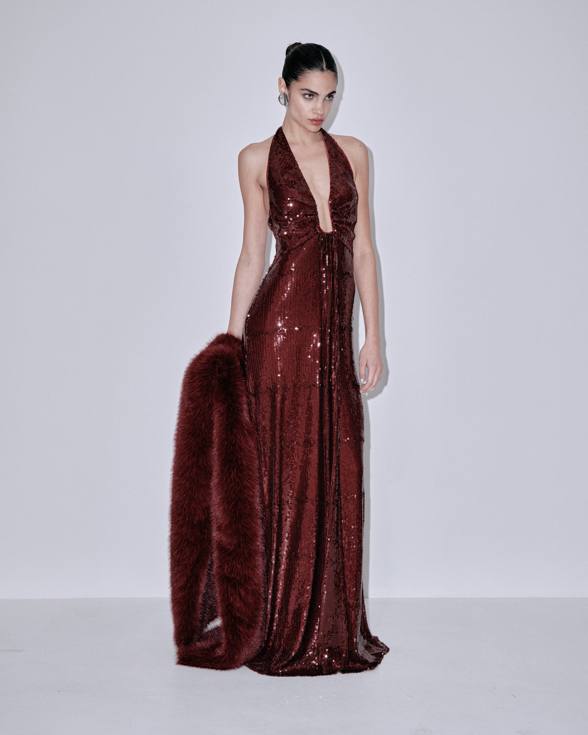 Wine sequin halter gown with faux-fur shoulder wrap, front angle