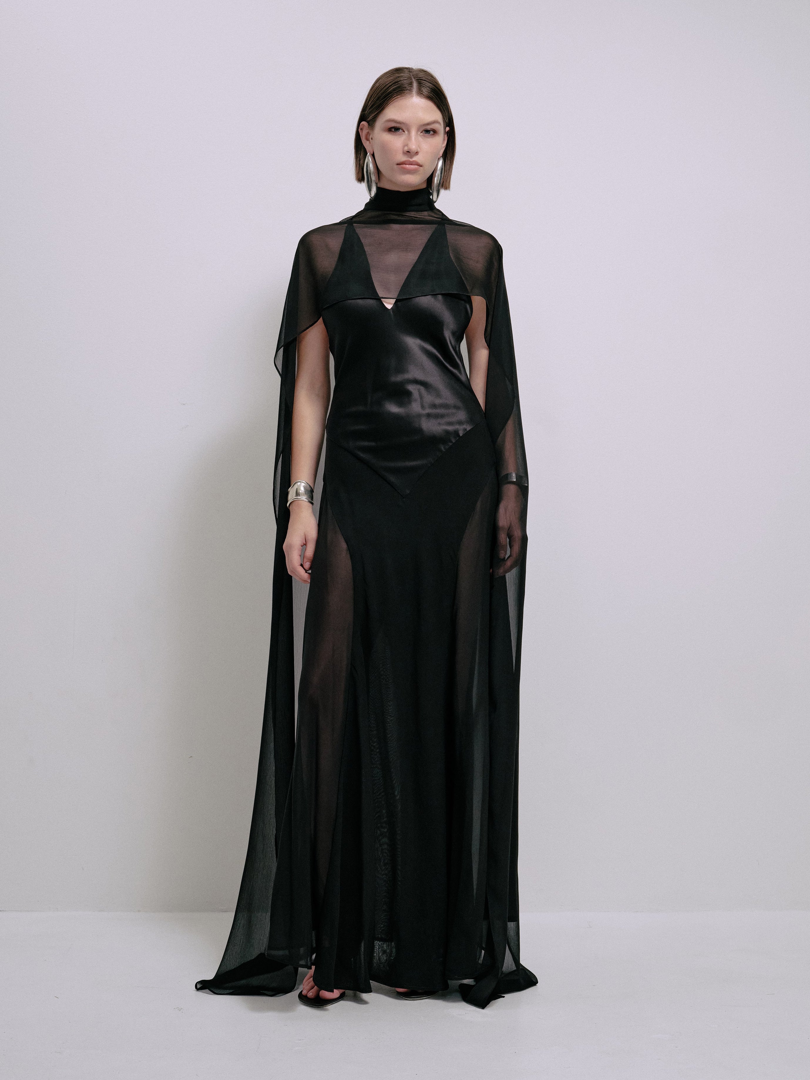 Black sleeveless satin maxi dress with V neck and sheer cape sleeves