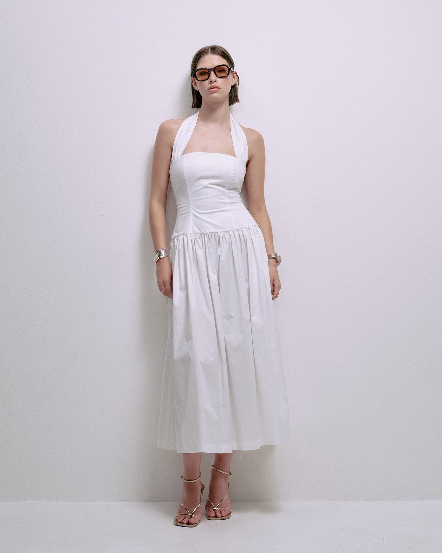 Sleeveless white midi dress with square neckline and pleated skirt front view
