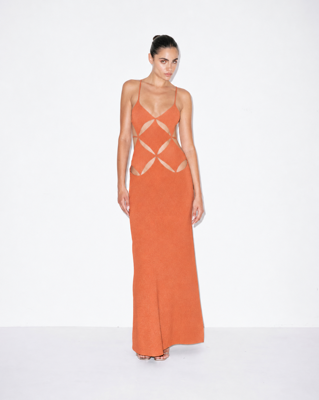 Orange maxi dress with spaghetti straps and geometric cutout pattern, front view