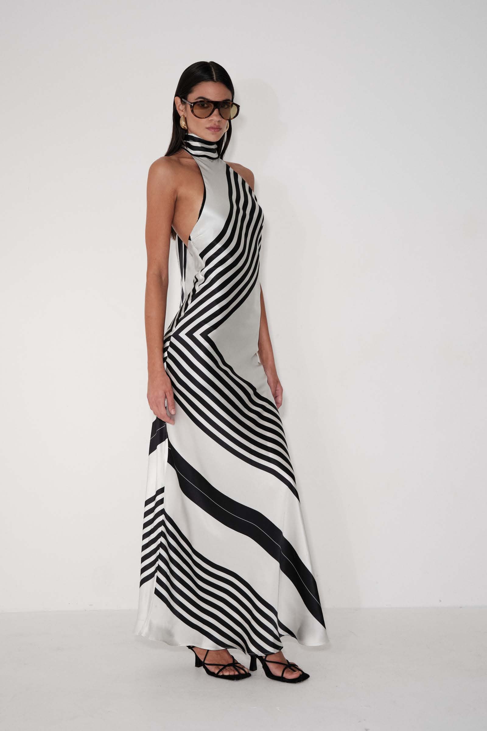 Woman wearing a black and white striped dress for the Delfi Summer 2026 campaign