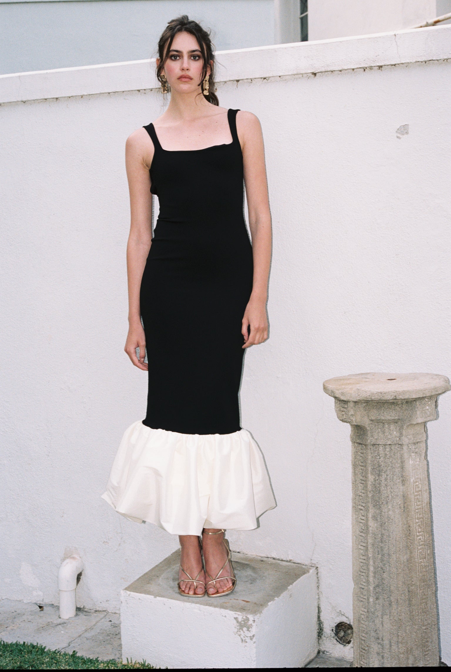 Sleeveless black dress with ivory ruffle hem and thin shoulder straps