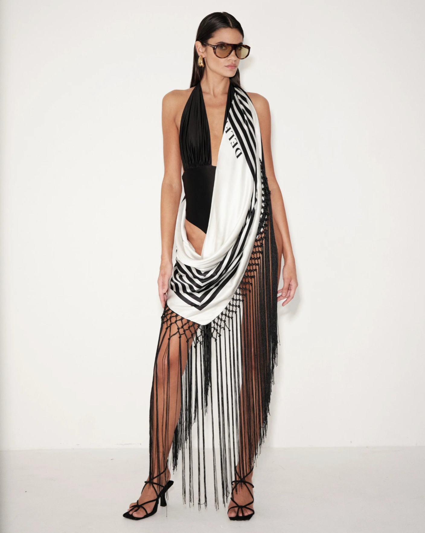 Black and white striped scarf with long fringe, draped at the waist and neck